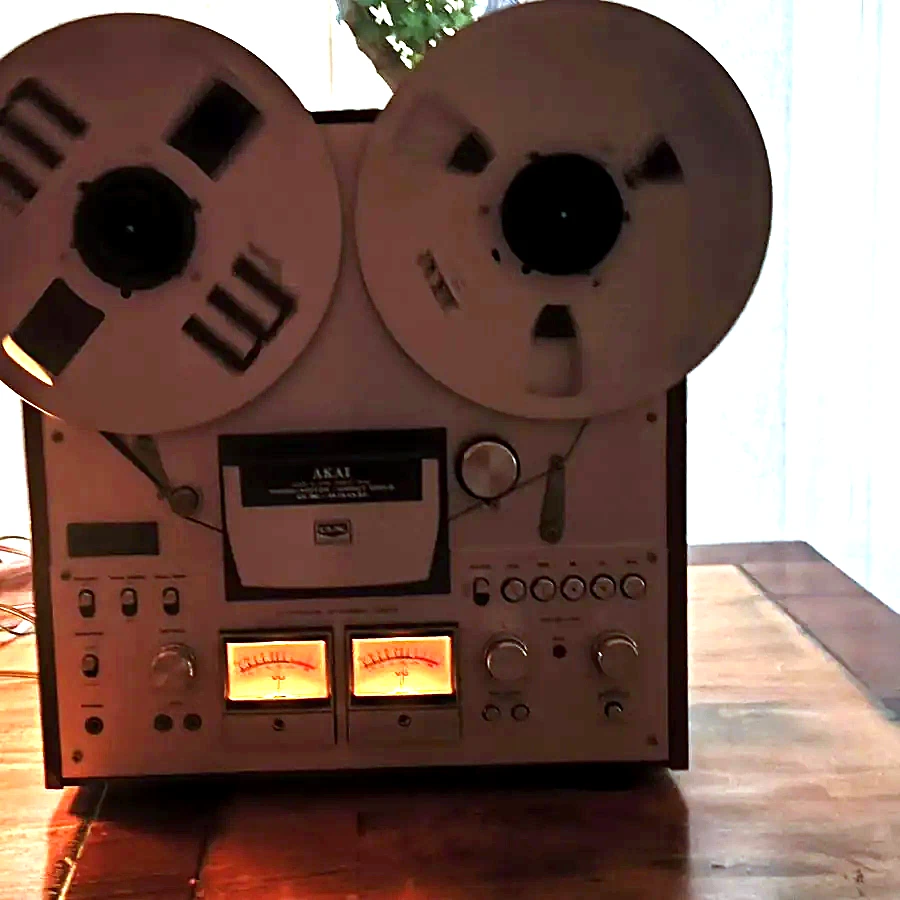 Die AKAI GX-630D mit zwei aufgelegten Spulen, vor einem Fenster.