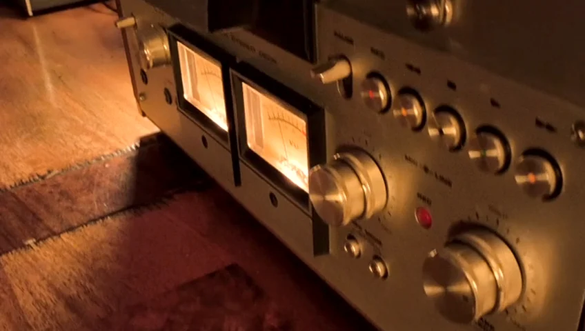 Die beleuchteten Anzeigen der Bandmaschine bewegen sich im warmen Licht.
